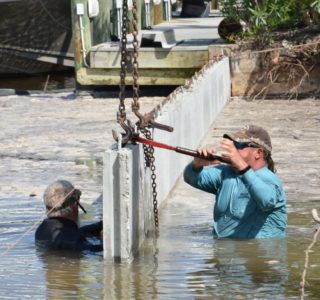 Bubba Williamson tightening a retaining chain across a new section of seawall. There is always an owner of Williamson and Sons on site to construct the new seawall.